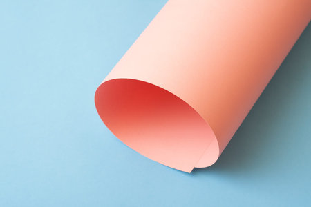 Rolled pink paper on blue background.