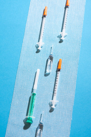 Syringes and ampules on sterile gauze on blue background.