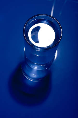 Dark blue monochrome image of a glass of water.の写真素材