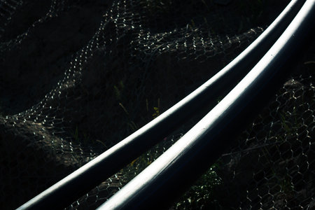 High contrast image of two platic water pipes on dark background.