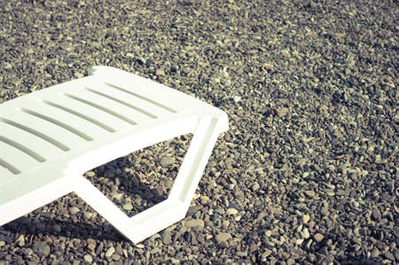 White plastic beach chair on the shore.の写真素材