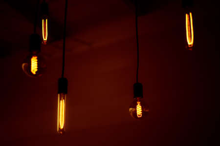 Group of tungsten light bulbs in the dark.の写真素材