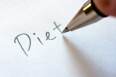 Close up image of writing a word DIET on a notebook paper.の写真素材