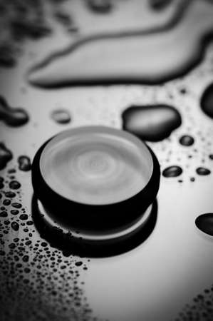 Black and white minimal motion blur image. Rotating round sphere on wet surface.の写真素材