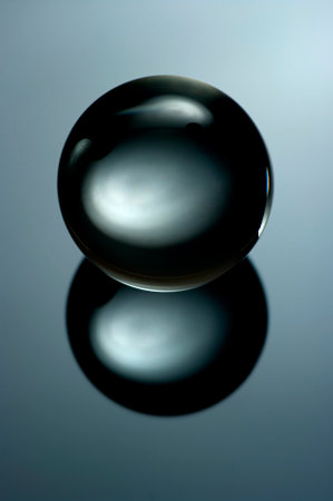 Abstract still life image of a glass ball in a low key. Geometric object with reflection, Glass sphere in a low key.の写真素材