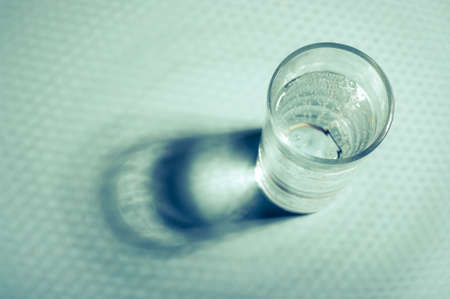 Glass of water with shadow. Minimal still life image of water.の写真素材
