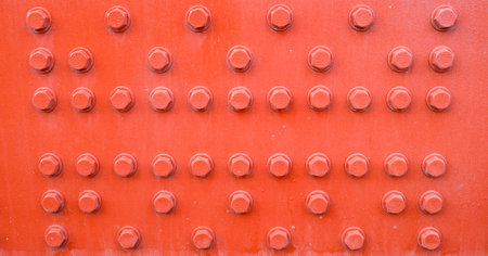 Red metal background with screwsの写真素材