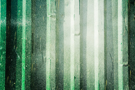 Green zinc fence background with paint spots and splashes.の写真素材