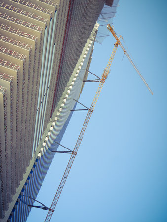 Modern unfinished skyscraper with a lifting crane.の写真素材