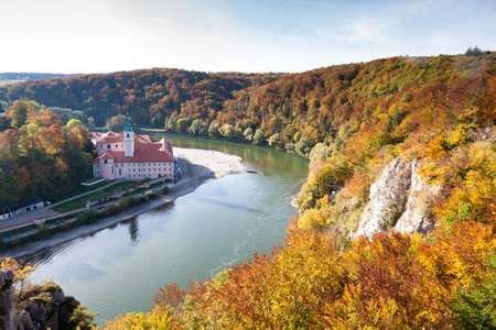 Weltenburg monastery and Donaudurchbruch at the Danube river in Bavaria, Germany surrounded by orange autumn colored treesの写真素材