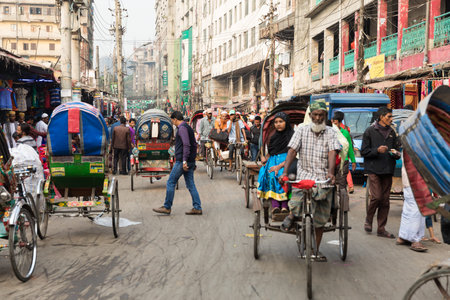 Busy traffic filling a street in central Dhaka. Cycle rickshaws, buses, people and cars compete for...