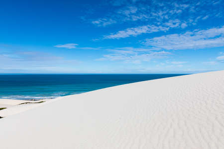 White Sand dunes and blue Ocean at De Hoop National Park, South Africaの写真素材