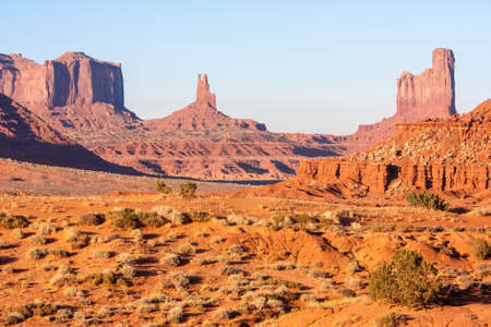 Sunset and strong colors at the buttes in The Monument Valley, Navajo Indian tribal reservation park. Deep blue sky with cloudy and red sand dust in a rough plateauの写真素材