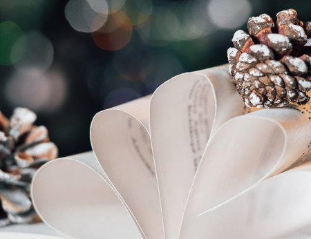 Christmas card with an open book and pine cones .