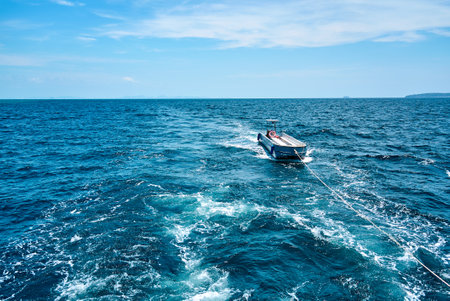Towed fishing boat navigating calm blue watersの写真素材