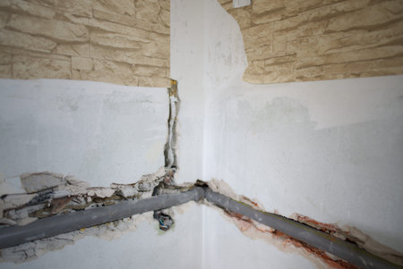 The plumbing work is currently in progress, showcasing exposed pipes and a bare floor in a bathroom...