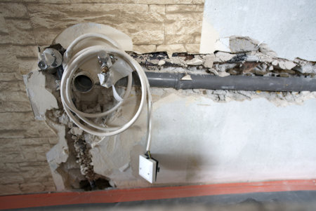 The plumbing work is currently in progress, showcasing exposed pipes and a bare floor in a bathroom renovation projectの写真素材