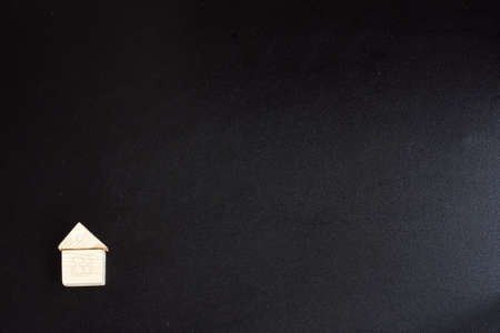 small bright wooden toy house on a dark backgroundの写真素材