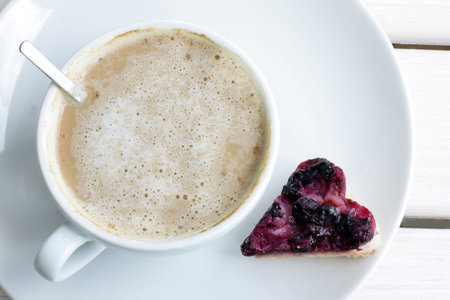 coffee with milk and berry cake in the form of heartの写真素材