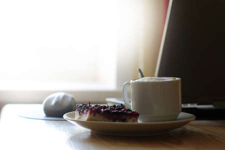 Coffee with sweet dessert is on your desktop with a laptopの写真素材