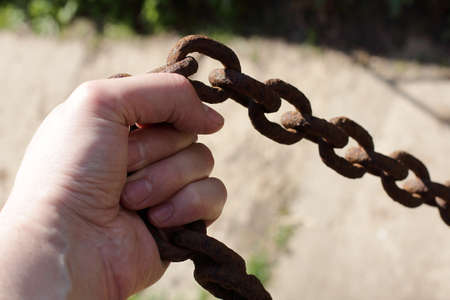 very  thick rusty chain in a man's handの写真素材