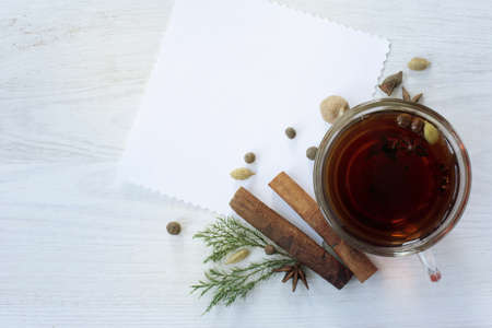 Black tea in a transparent mug with aromatic spices and card for inscriptions top view / warming drink for moodの写真素材