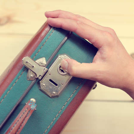 human hand opens retro suitcase top view / baggage checkの写真素材