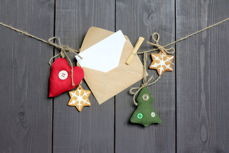letter hanging on a rope, together with the tree, heart and ginger and stars on a dark wooden background / congratulation to holidayの写真素材