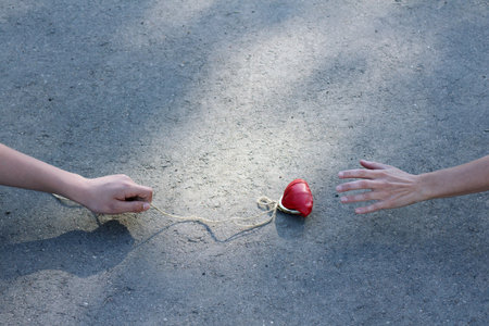 the lure of the red purse tied to a rope on the background of asphalt road / bad businessの写真素材