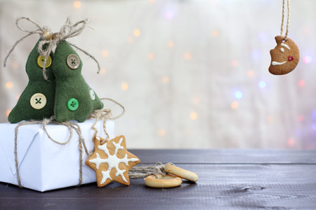 holiday table with gift and delicious gingerbread on the background of Christmas lights /...