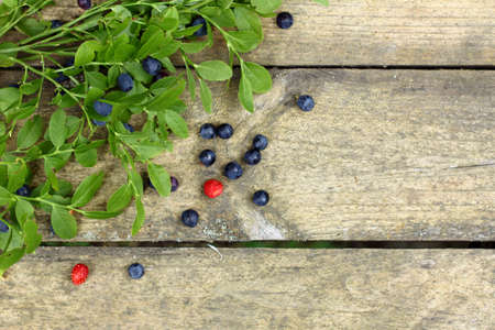 flat layout with forest blueberries and strawberries on old wooden surface top view / still life with forest berriesの写真素材