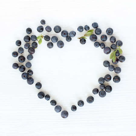 flat lay of the heart symbol wild blueberries top view / idea favorite berry dessertの写真素材