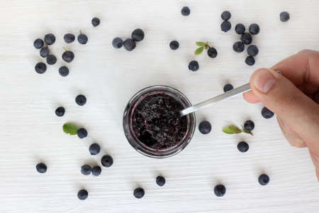 tasting berry jam a small spoon on a background of berries / jam tasting of wild berriesの写真素材