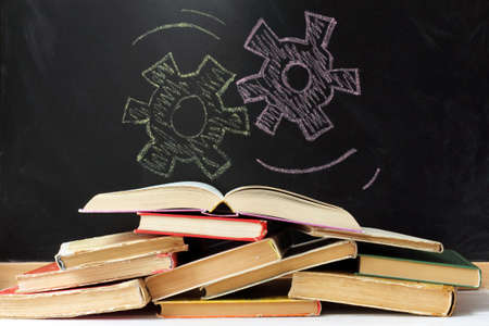 many piled in a heap of worn-out books on a background of painted by chalk mechanism / concept of educational processesの写真素材