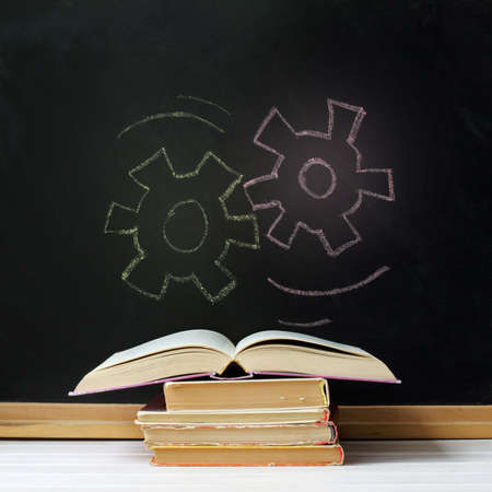 open book on background of boards with the drawn chalk gears / idea education conceptの写真素材