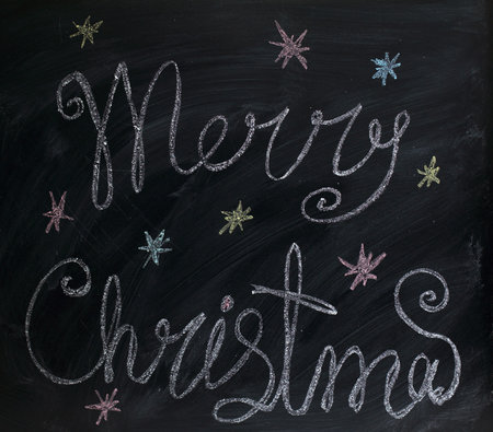 greetings Merry Christmas painted by with chalk on blackboard / holiday backgroundの写真素材