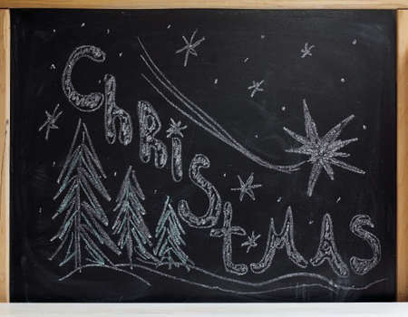 Congratulations on Christmas drawn with chalk on blackboard / holiday wishの写真素材