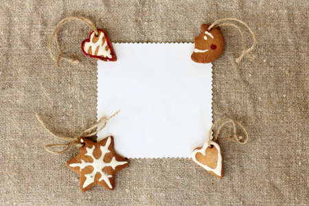 flat lay with Christmas homemade ginger cake and a card for inscriptions on a background of linen fabric / favorite tasty holiday decorationの写真素材