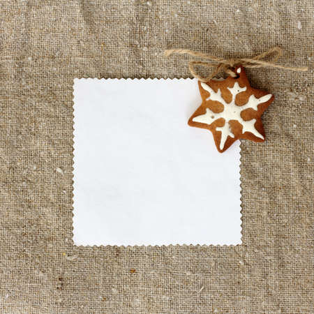 flat lay with soft homemade Christmas cake and a card for inscriptions on a background of linen fabric / festive snowflake for congratulationsの写真素材