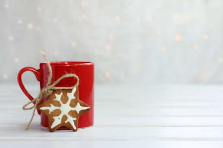 Festive gingerbread with red cup on the background lights / delicious Christmas morningの写真素材