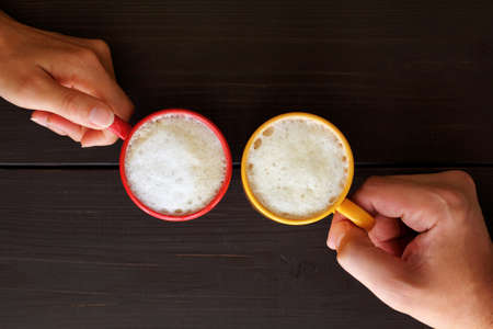 two hands with colored circles view from above of cappuccino / coffee and choose the moodの写真素材