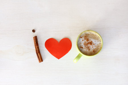 flat layout with heart symbol and cup of frothy cappuccino with cinnamon top view / I love coffee