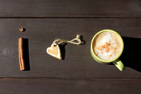 flat layout with a frothy coffee with cinnamon and gingerbread in the form of heart / my favorite aromatic and sweet breakfastの写真素材