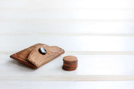 little old retro purse and a stack of coins on a light wooden background / small beginning of big businessの写真素材