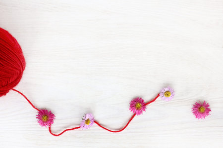 unwound a skein of thread of red color decorated with flowers / idea for fashion design