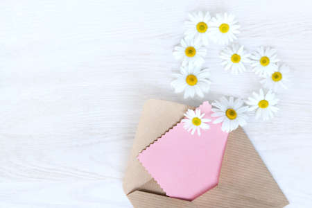 flat lay with an open letter to the paper, flying off daisies outside view from above / idea messages from your heartの写真素材