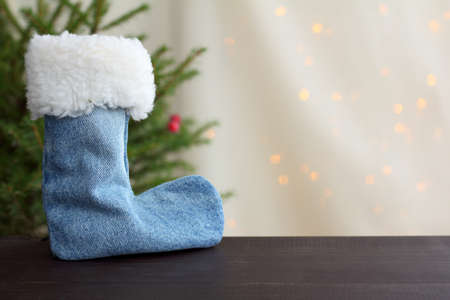 boot for gifts under the Christmas tree, against a background of holiday lights / new year eveの写真素材
