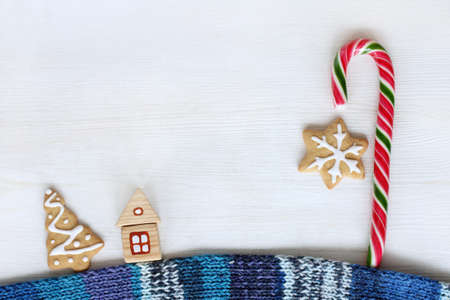 flat layout of a wooden house on a warm scarf and striped candy and cookies top view / street sweet fairy lanternsの写真素材