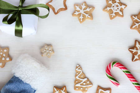 flat layout of festive cookies figure with a striped candy and gift top view / Christmas surprises from Santa's bootの写真素材