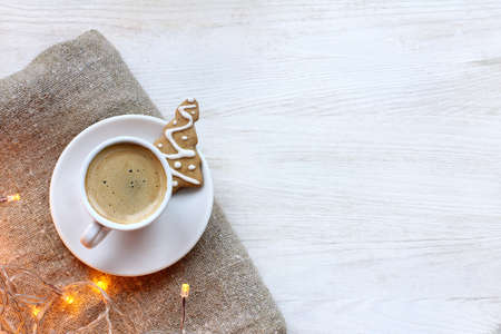 black coffee in small white cup with festive garland top view / warm aroma holidaysの写真素材